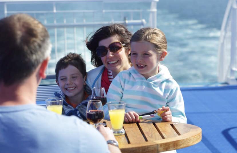 Family enjoying drinks on a ferry deck in France for families.